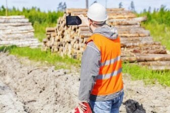 A consulting arborist takes pictures of a property development with his smartphone